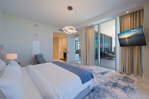 Una habitación de hotel con cama, televisión, escritorio y vistas al exterior.