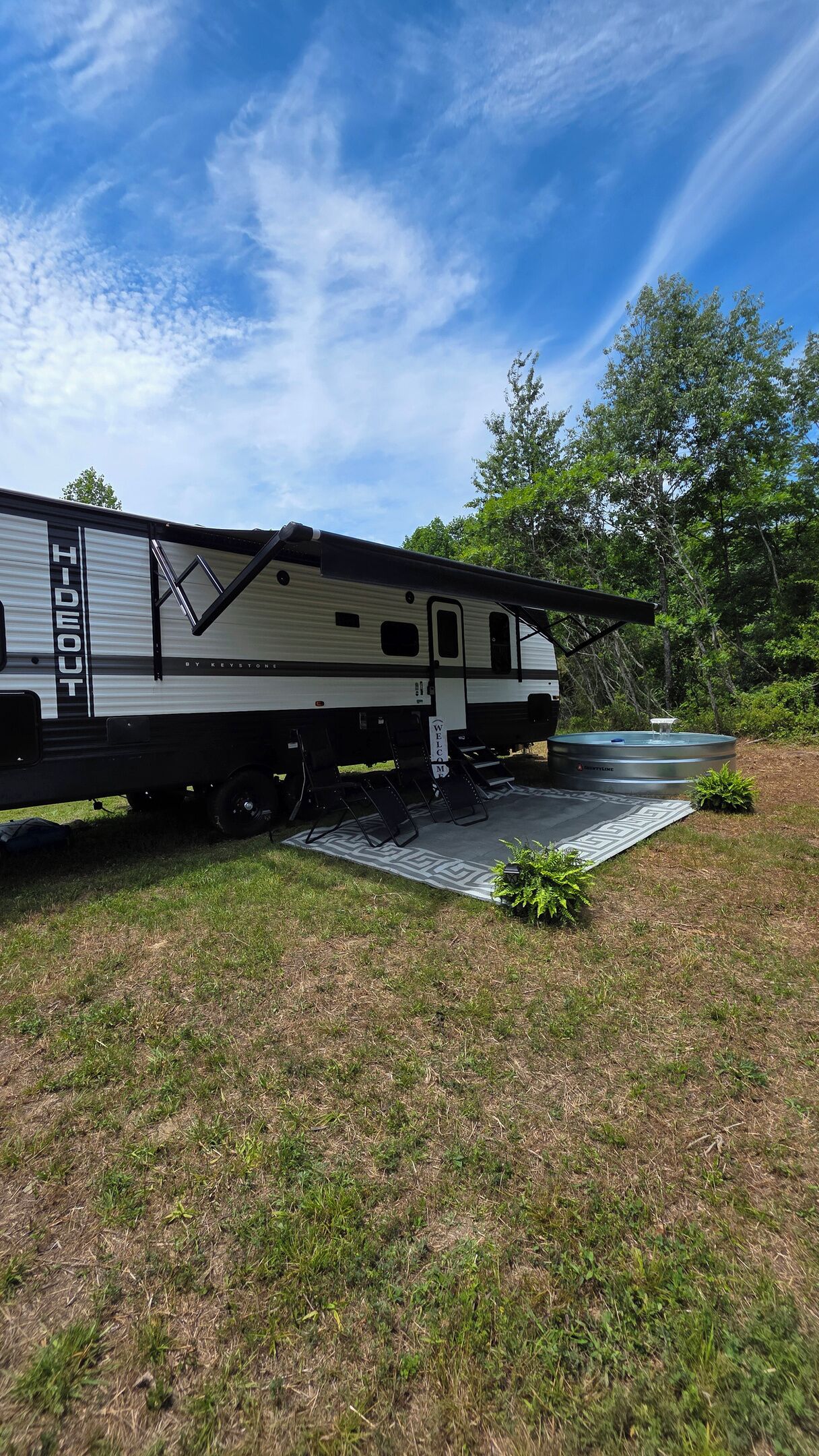A recreational vehicle with a 'HIDEOUT' sign, a water feature, and a welcome mat.. The Hideout | Cowboy Pool & Green River Lake