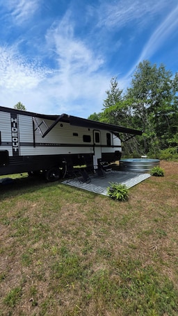 A recreational vehicle with a 'HIDEOUT' sign, a water feature, and a welcome mat.. The Hideout | Cowboy Pool & Green River Lake