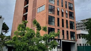 A multi-story building with a brick facade, large windows, and a visible entrance. - LUUM 402 (Guadalajara)