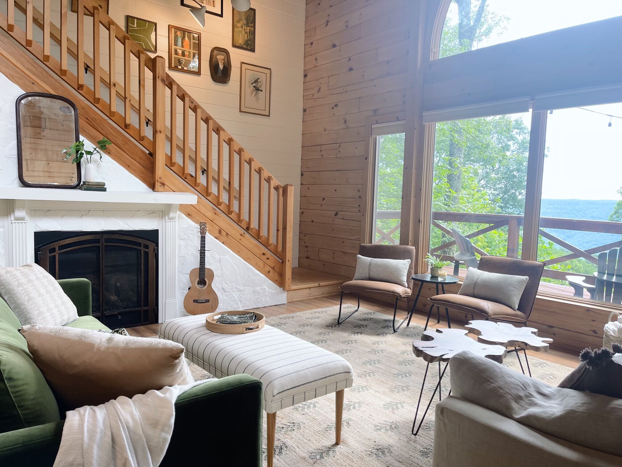 A cozy living room with a fireplace, a staircase, and a view of the outdoors.