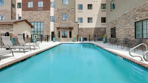 A swimming pool with lounge chairs and a no diving sign, surrounded by multi-story buildings with stone and brick facades. - 1BR Suite w/ 2 Queens | Breakfast, Pool & Fire Pit (Schertz)