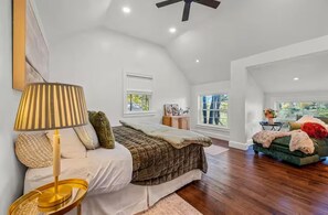 Ein Schlafzimmer mit Bett, Lampe, Deckenventilator und Blick ins Freie.