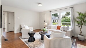 Un salon spacieux comprenant un ensemble de canapés, une table basse et une plante en pot.