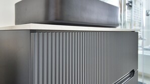 Eine moderne Küche mit Metallausstattung, einem eingebauten Backofen und einer Spritzschutzleiste aus Edelstahl.