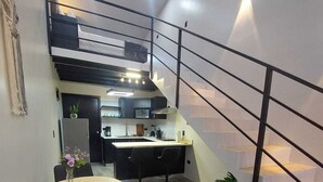 A modern kitchen with a dining area, a staircase, and a potted plant. - Romantic 1-bedroom apartment with AC in fantastic El Castillo (El Castillo)