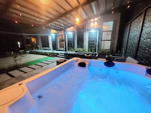 Ein Whirlpool mit Steinwand und Außenbereich mit Sitzgelegenheiten.