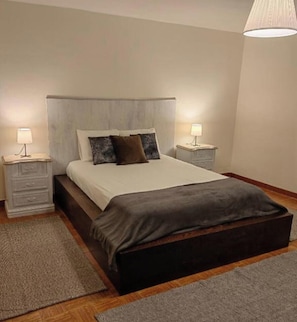Una camera da letto con un letto, due comodini, una lampada e un lampadario.