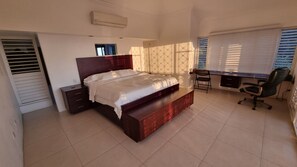 Un dormitorio con cama, escritorio, silla y armario.