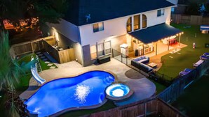 Ein Garten mit Swimmingpool, Whirlpool und Sitzgelegenheit im Freien.