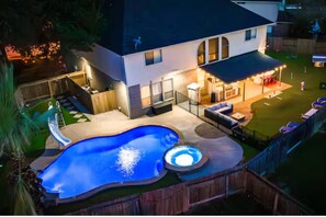Ein Garten mit Swimmingpool, Whirlpool und Sitzgelegenheit im Freien.