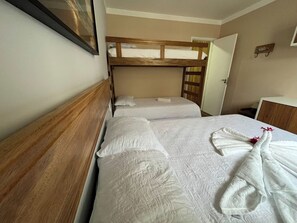 Ein Hotelzimmer mit zwei Betten, einem Holz-Kopfteil und einem kleinen Nachttisch.
