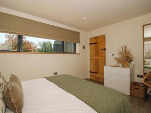 Un dormitorio con cama, cómoda, ventana y puerta.