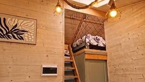 A wooden interior with a bunk bed, a ladder, and a door. - Gîte Hydra Nature (Conteville)