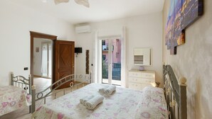 A bedroom with two beds, a ceiling fan, a sliding glass door to a balcony, and a wall-mounted TV. - Casa Anna Standard Faito View in Pimonte – Comfort e Vista Montagna (Pimonte)