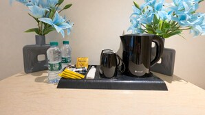 A table with a black mug, two water bottles, a tissue, and a small packet of tissues. - ROYALTY GROUP (Riyadh)
