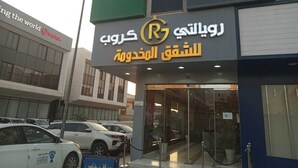 A building with a sign in Arabic and English, indicating a business or service establishment. - ROYALTY GROUP (Riyadh)