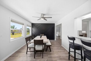 A modern kitchen with a dining area, a ceiling fan, and a view of the outdoors. - Waterfront beauty in Overbrook Gardens (Englewood)