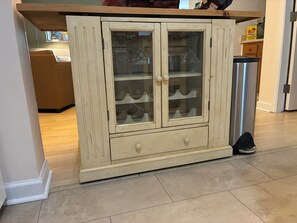 Eine Küche mit einem cremefarbenen Schrank mit Glastüren und einer Schublade.
