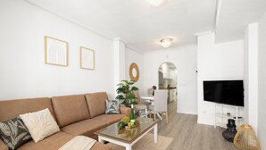 Uma sala de estar moderna com sofá, mesa de centro e televisão.