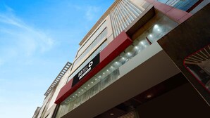 A hotel with a modern facade, a prominent sign indicating it is a hotel, and a clear sky in the background. - Classic The Urban (Noida)