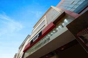 A hotel with a modern facade, a prominent sign indicating it is a hotel, and a clear sky in the background.