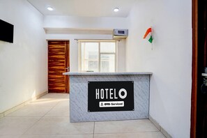 A hotel reception desk with a sign indicating it is serviced by OYO.