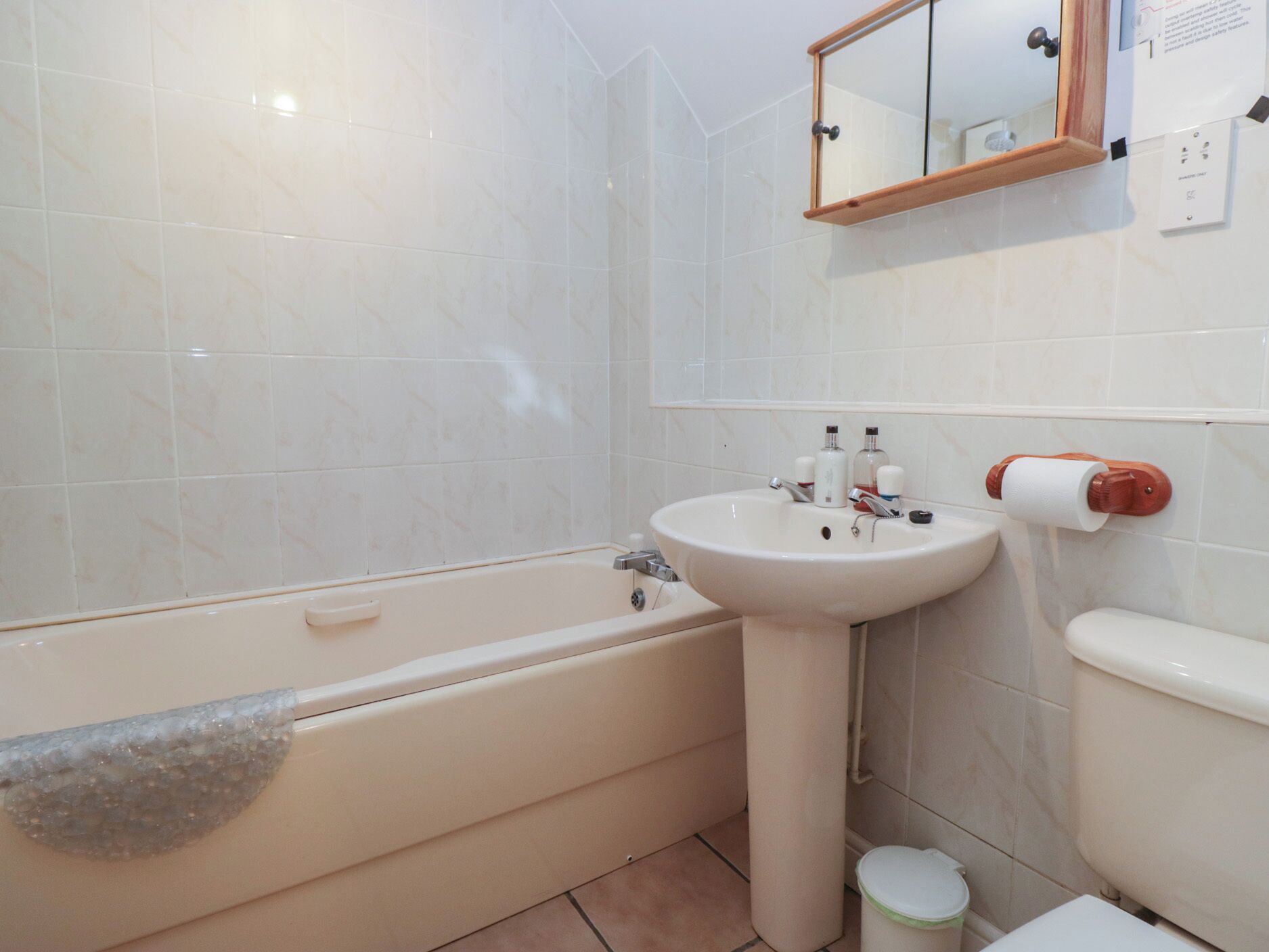Un baño con bañera, lavabo, inodoro y espejo.