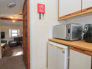 Eine kleine Küchenzeile mit einer Mikrowelle, einem Toaster und einem Kühlschrank.