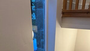 A narrow stairwell with a window, a potted plant, and a white wall. - Cosy Lakeside Retreat in Mountshannon (Mountshannon)