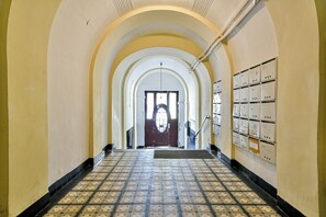 A hallway with arched ceilings, a patterned floor, and a row of electrical boxes on the right. - Buda Bliss Garden Budapest (Budapest)