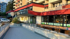 Un hôtel à plusieurs étages, doté d’un auvent rouge, d’un espace dédié aux enfants et d’un parking.