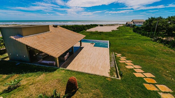 A house with a wooden deck, a swimming pool, and a view of the beach. - Casa P na Areia com Piscina a em Lu s Correia (Luis Correia)