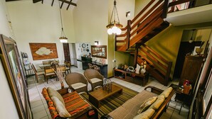 A spacious living room with a sofa, chairs, a coffee table, and a staircase. - Casa P na Areia com Piscina a em Lu s Correia (Luis Correia)