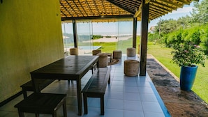 An outdoor seating area with a table and benches, a pergola, and a view of the landscape. - Casa P na Areia com Piscina a em Lu s Correia (Luis Correia)