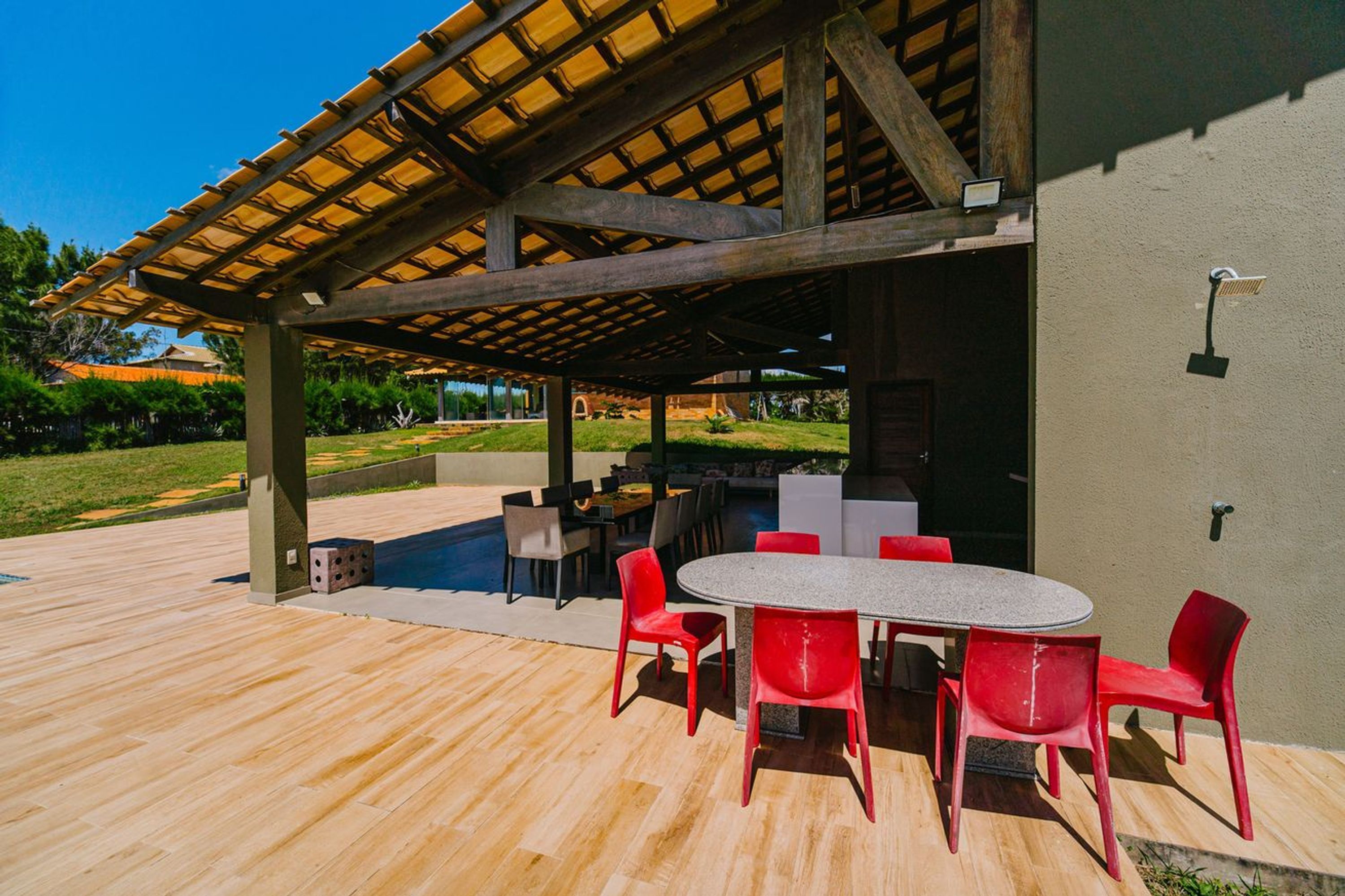 Eine Terrasse im Freien mit überdachter Sitzgruppe, Pool und Essbereich.