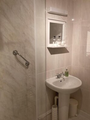 Une salle de bain équipée d’un lavabo, d’un miroir et d’un porte-serviettes.