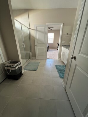 A hallway with a glass door, a bag, and a blue rug.