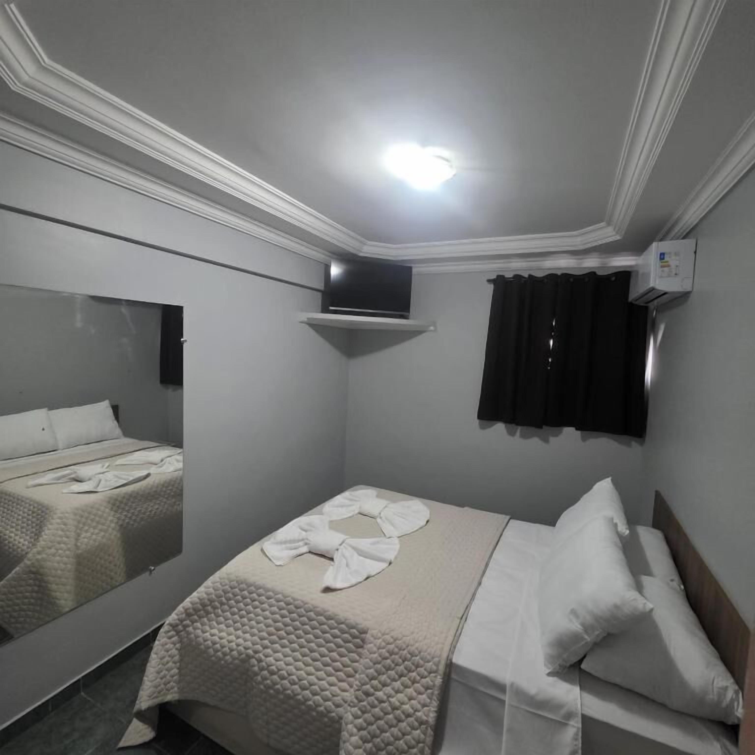 Une chambre à coucher avec un lit, un téléviseur et un appareil de climatisation.