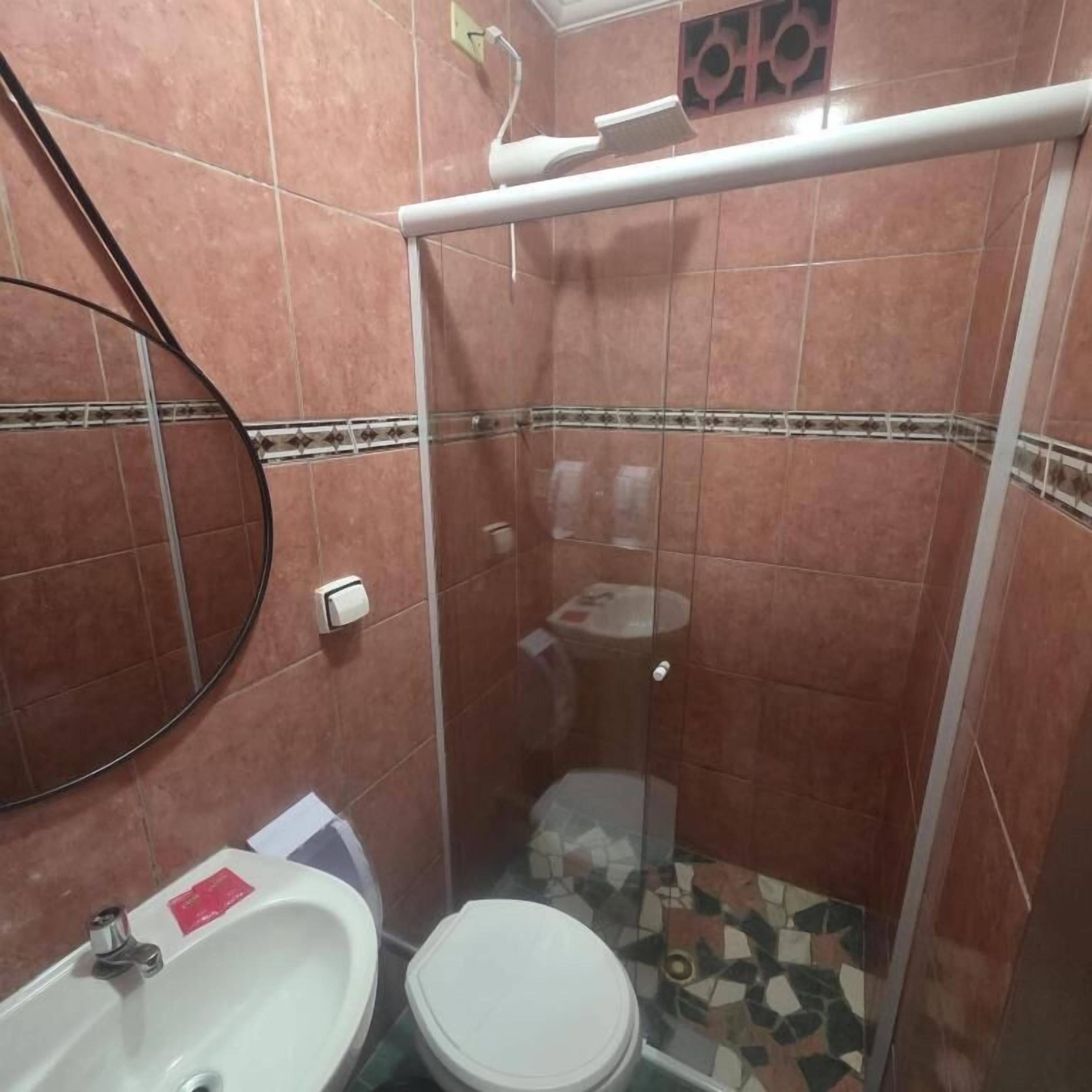 Un bagno con doccia, WC e lavandino.