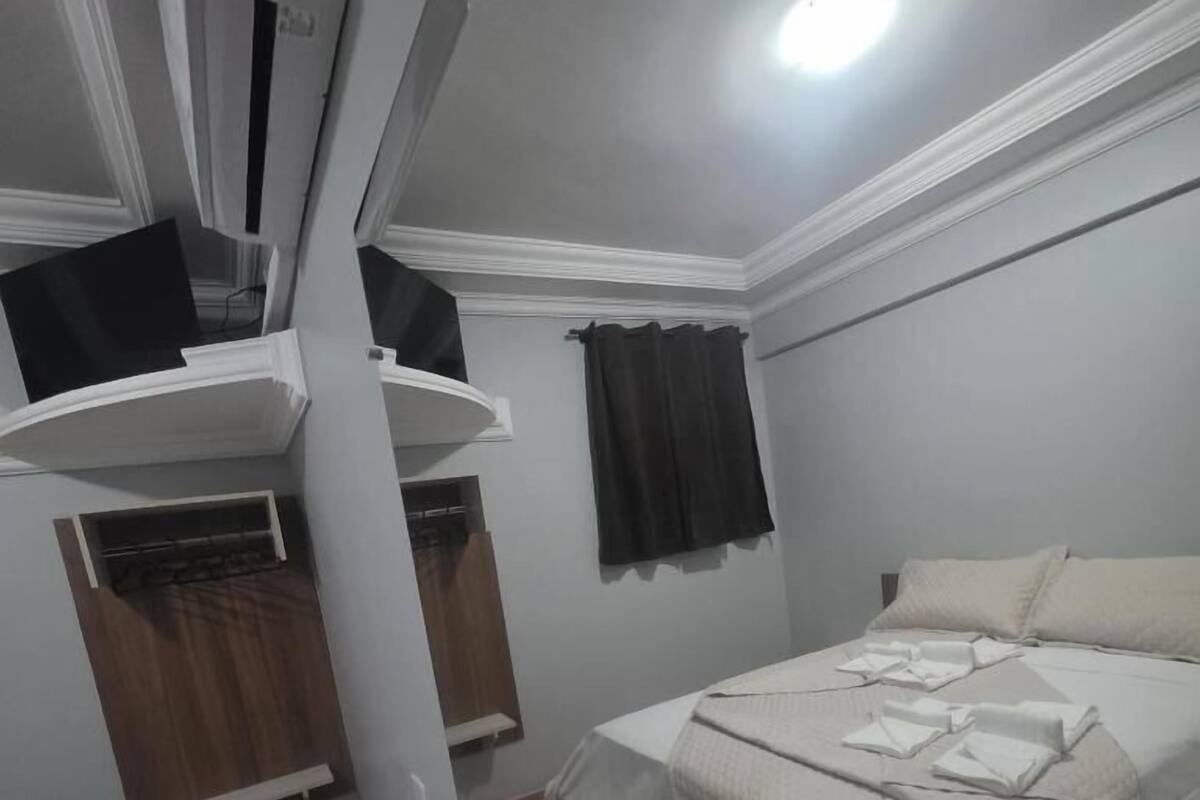 Un dormitorio con cama, armario y estantería.