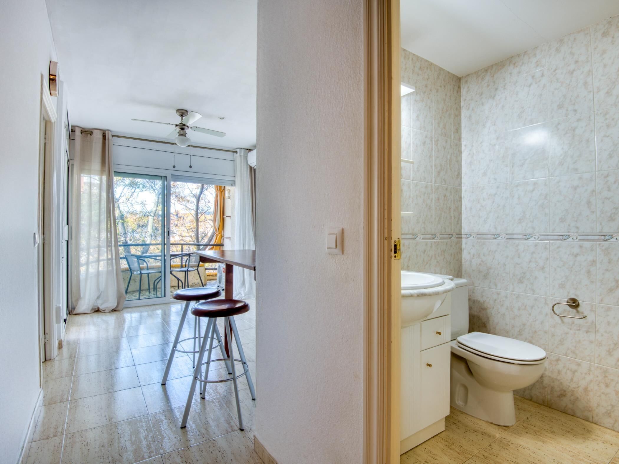 A bathroom with a toilet, sink, and a glass shower enclosure.