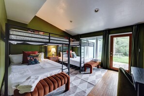 Una habitación con literas, un escritorio, una silla y vistas al exterior.