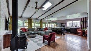 A spacious living area with a fireplace, a sofa, a coffee table, and a kitchen in the background.