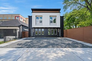 A modern two-story house with a driveway and a fenced backyard. - Suite Duplex @Downtown Unit B 6 Br/6 Bath (Houston)