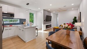 Una cucina moderna con mobili bianchi, un forno a microonde integrato e una grande isola.