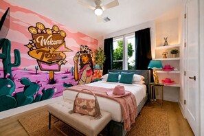 Une chambre à coucher avec un lit, une table de chevet, une fresque murale et une fenêtre.