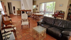 A spacious living area with a fireplace, leather sofa, dining table, and chairs. - Large house in the heart of the village of Gruissan (Gruissan)