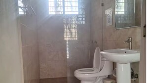 Un bagno con il water, un lavandino e un piccolo cestino.