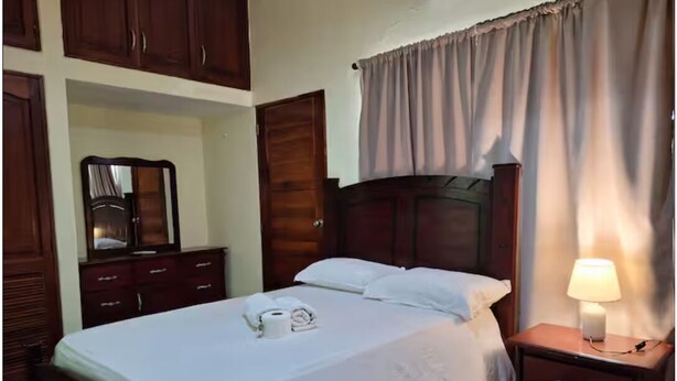 Una camera da letto con un letto, un comodino, uno specchio e mobili in legno.